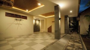 A spacious interior with a checkered floor, a staircase, and a hallway leading to a door. - Sleepwell Seminyak (Bali)