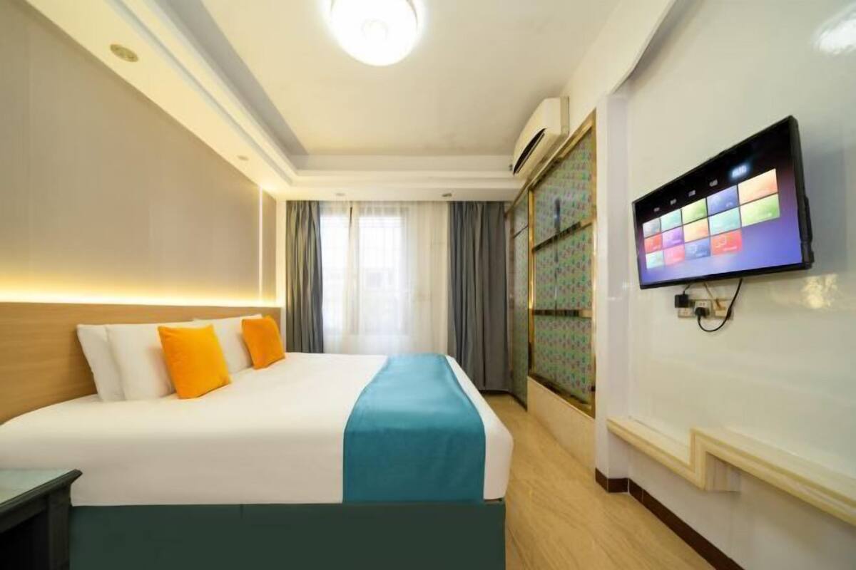 A hotel room with a bed, a television, and a wardrobe.