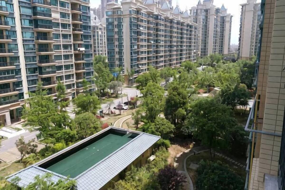 A residential area with high-rise buildings, a swimming pool, and green spaces.