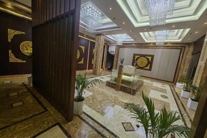 A hotel lobby with a reception desk, seating area, and decorative elements. - Ding Chang Hotel (Xiangzhou)