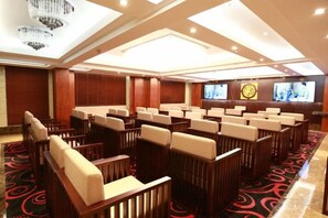 A conference room with rows of chairs, a large screen, and a carpeted floor. - Ding Chang Hotel (Xiangzhou)