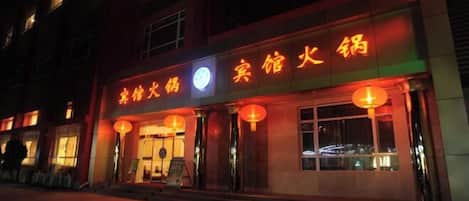 A building with illuminated signage in a foreign language, suggesting a hotel or restaurant.