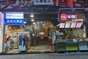 A storefront with a sign for a stationery store and a food stall. - Meicheng Hotel (Guangzhou Zhujiang New Town Subway Station) (Guangzhou)