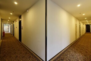 A long, narrow hotel corridor with doors on both sides, carpeted flooring, and recessed lighting. - Meicheng Hotel (Guangzhou Zhujiang New Town Subway Station) (Guangzhou)