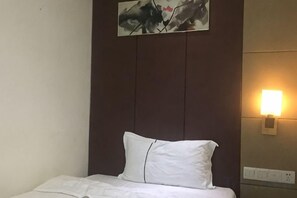 A hotel room with a bed, a wall-mounted light, and a painting. - Meicheng Hotel (Guangzhou Zhujiang New Town Subway Station) (Guangzhou)