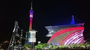 A nighttime view of a cityscape with illuminated buildings, including a tall tower and a modern structure with curved lines. - Meicheng Hotel (Guangzhou Zhujiang New Town Subway Station) (Guangzhou)