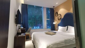 A hotel room with a bed, a desk with a chair, a TV, and a window with curtains. - Meicheng Hotel (Guangzhou Zhujiang New Town Subway Station) (Guangzhou)