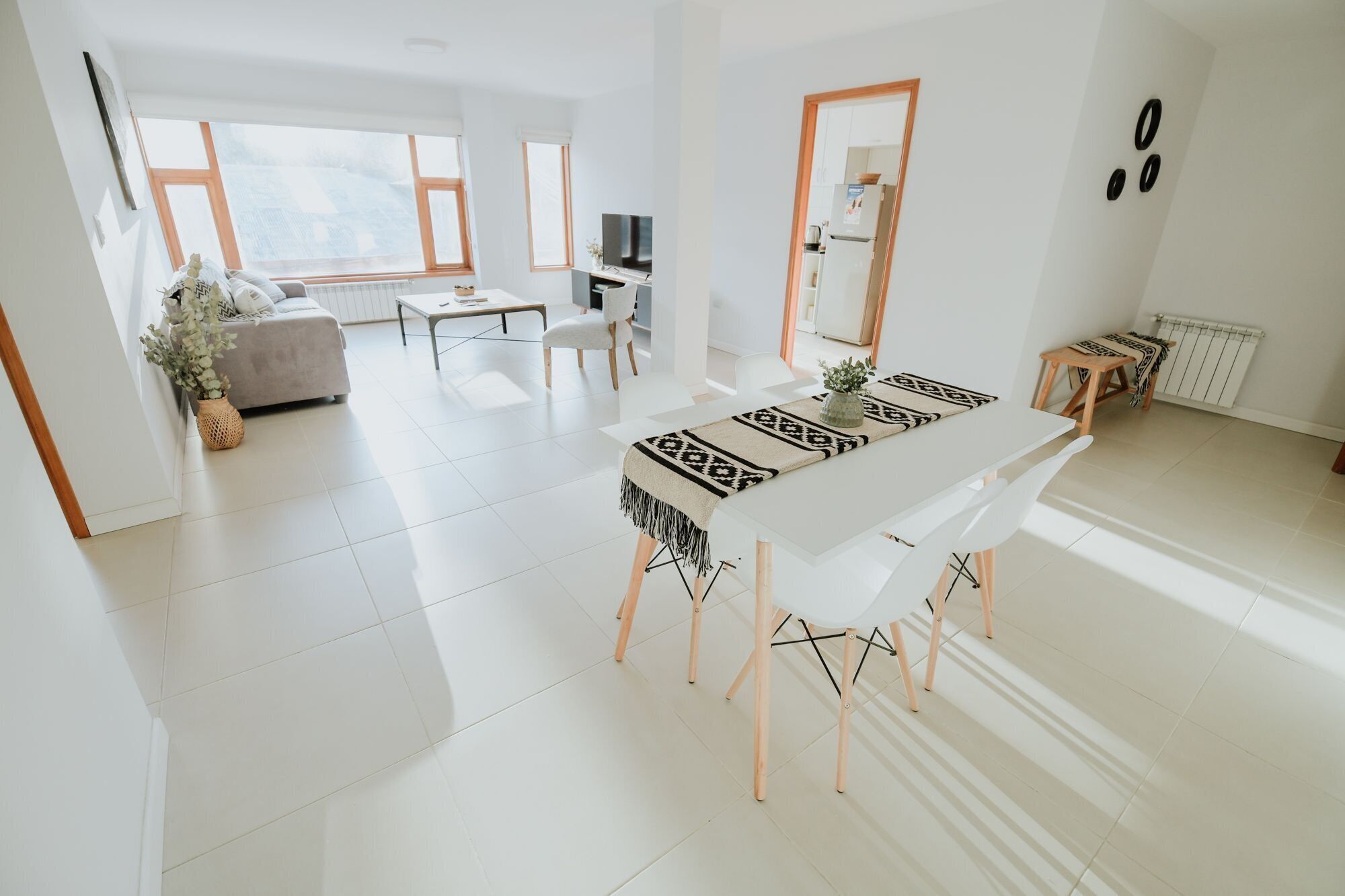 A spacious living area with a dining table, sofa, and a view of the city.