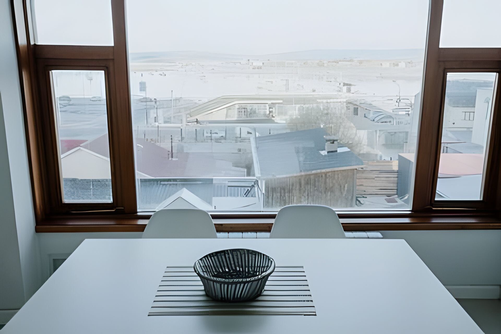 Vista desde una ventana, con una mesa y un cuenco en primer plano.