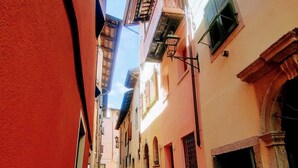 A narrow cobblestone street flanked by buildings with balconies and arched windows. - Casa Marlò Centro Storico (Cividale del Friuli)