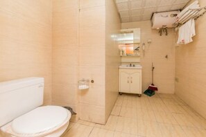 Un baño con inodoro, lavabo y zona de ducha.