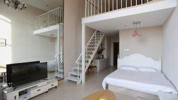 A modern bedroom with a bed, a TV, and a staircase leading to an upper level.