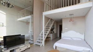 Un appartement moderne doté d’une télévision, d’un lit, d’un escalier et d’un balcon.