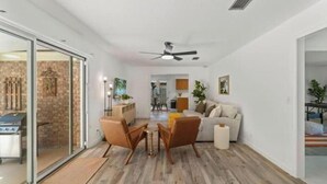 A modern living room with a sofa, two armchairs, a coffee table, and a fireplace. - Relaxing SWEET HOME 9mi Downtown Pool&Hot tub. (Jacksonville)