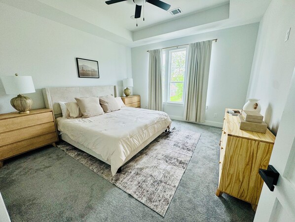 A bedroom with a bed, bedside tables, a nightstand, a window with curtains, and a ceiling fan. - Home just minutes from Downtown,Airport’s (Houston)