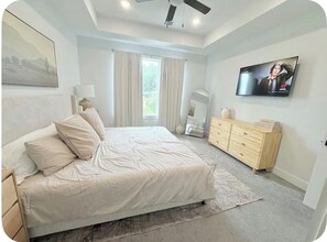 A bedroom with a bed, a dresser, a TV, and a ceiling fan. - Home just minutes from Downtown,Airport’s (Houston)