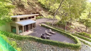 Una casa moderna amb terrassa, amb seients relaxants i una taula petita.