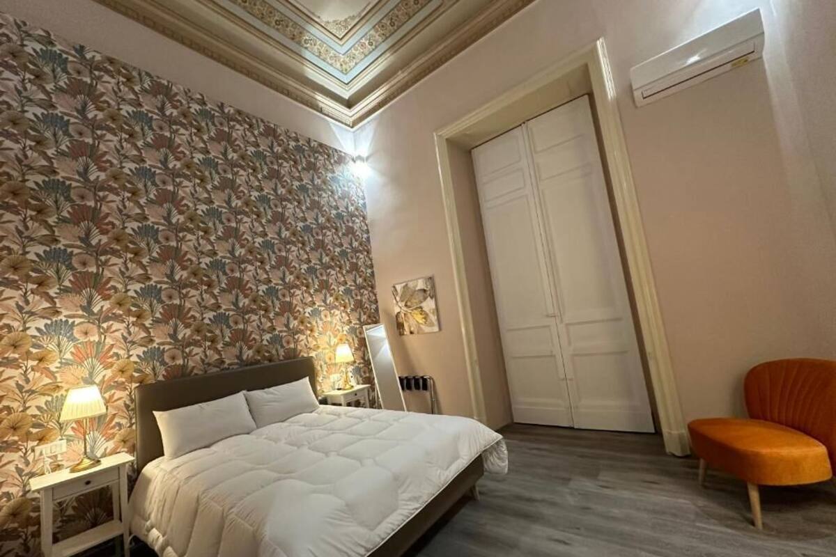 Une chambre à coucher comprenant un lit, une table de chevet, une chaise et une armoire.