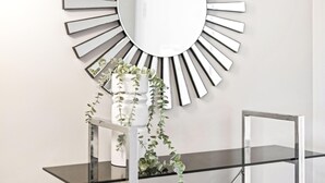 A modern interior with a sunburst mirror, a glass shelf with plants, and a metal frame structure. - 2 Bed 1 Bath Apartment at Chevron - Q Stay (CHEV 3107 - 2N - NB) (Surfers Paradise)