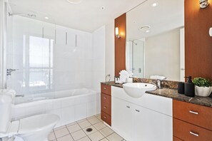 Enjoy a refreshing soak in the large bathtub or invigorate with a shower, both offering a clear view of the outside.