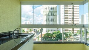 Una cocina con un ventanal grande, un lavabo y armarios.