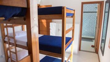 A bunk bed room with a wooden frame, a white cabinet, and a tiled floor.