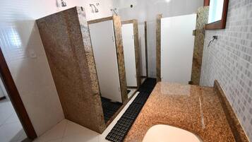 A bathroom with a granite countertop, a white sink, and a mirror.