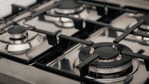 Gros plan d’une cuisinière à gaz dotée de quatre brûleurs et d’un bouton de commande.
