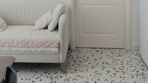 Une pièce avec une porte blanche, un canapé blanc et une petite table.