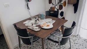 Une table à manger ornée d’un chemin de table en dentelle, d’un porte-bougie en verre et d’une assiette de pâtisseries.