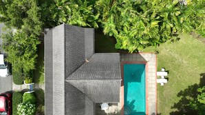 A residential property with a swimming pool, a covered patio, and a well-maintained lawn. - Charming 3-bedroom Gingerbread Style Villa in Bon Accord, Tobago (Bon Accord)