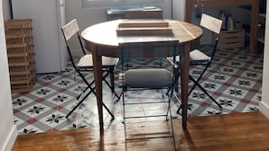 A kitchen with a round table and chairs, a window, and a tiled floor. - Pretty, quiet vacation home with wooded garden  (Perigny)