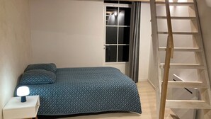 A bedroom with a bed, a nightstand, a window with curtains, and a wooden ladder. - Pretty, quiet vacation home with wooded garden  (Perigny)