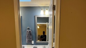 A bathroom with a mirror, sink, and cabinets. - Near ACOM and hospital , 2-bedroom house in charming Dothan with WiFi, AC.  (Dothan)