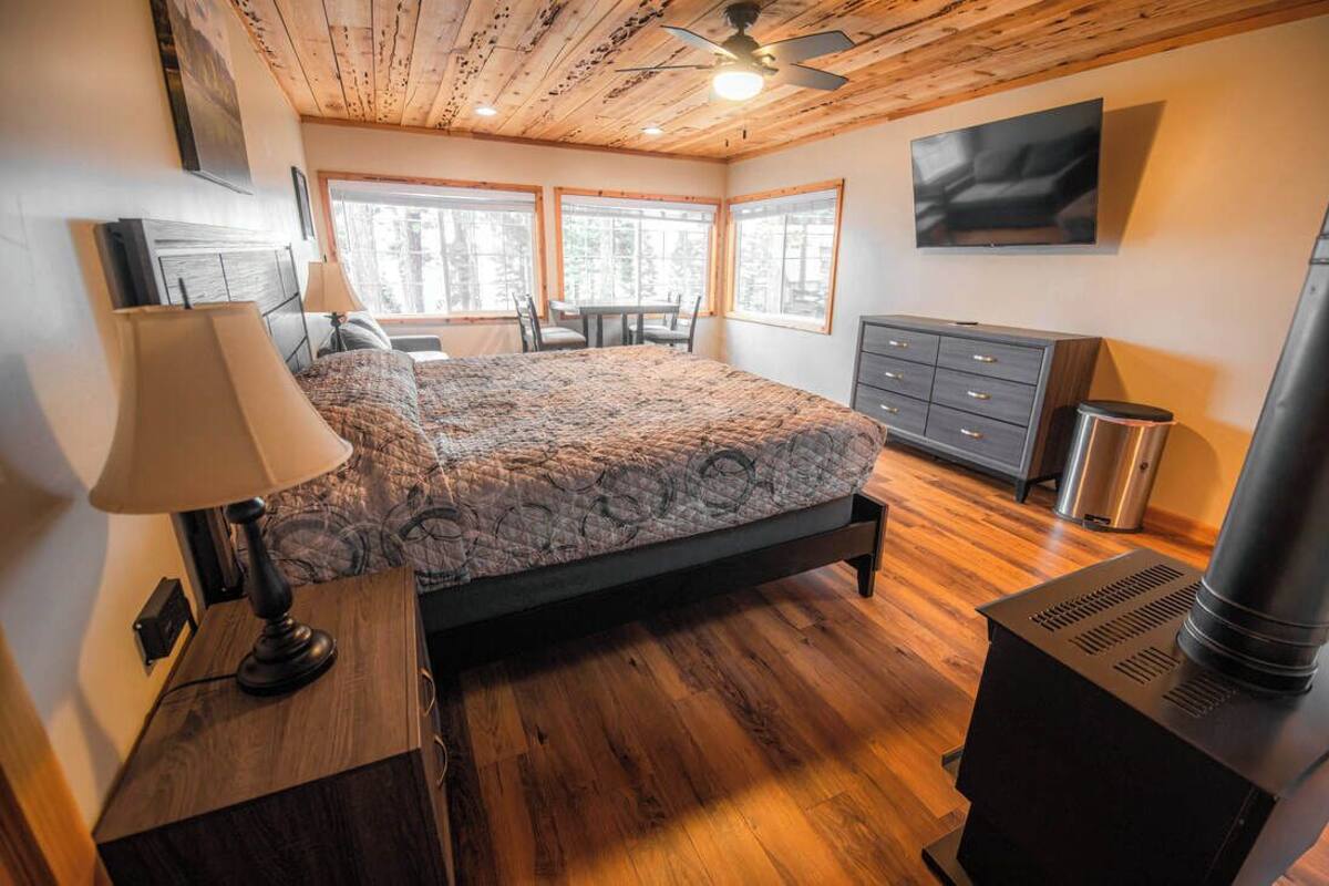 Un dormitorio con cama, cómoda, calefactor y ventana.