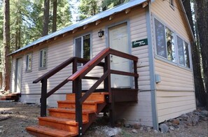 A small cabin with a wooden staircase leading to a door marked 'Lodge Pine.' - Plumas Pines Resort (Canyondam)