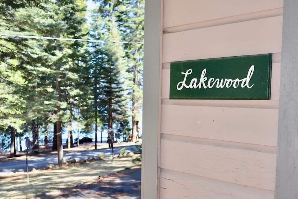 Un letrero verde con la palabra 'Lakewood' en un edificio de tonos claros.