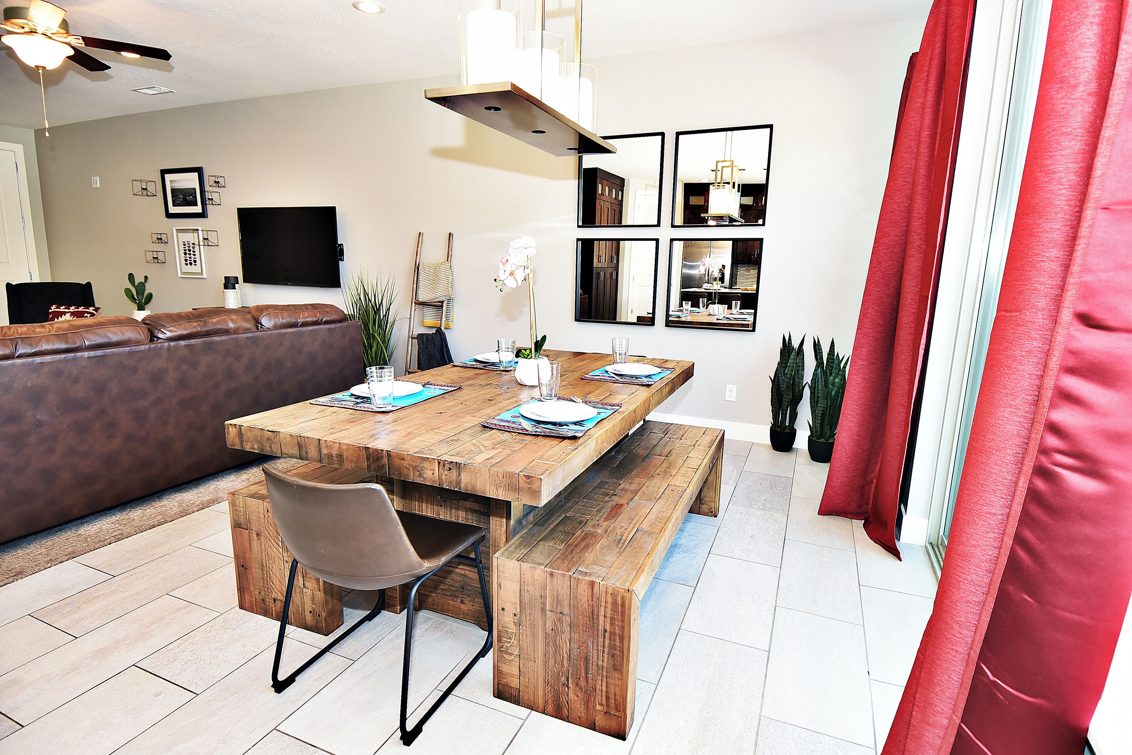 A dining area with a wooden table, benches, and chairs.