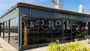 Un bar-restaurant moderne doté de grandes baies vitrées et d’un auvent en métal.