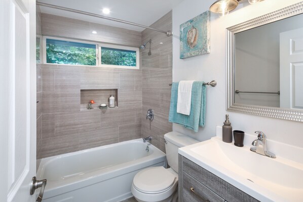 A modern bathroom with a bathtub, toilet, and vanity. - The Woodlands Estate - Texas (Houston)