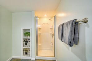 Een douche met glazen wand en een handdoekhouder aan de muur.