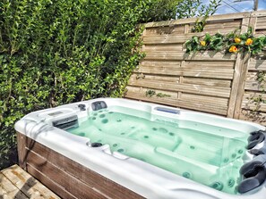 A hot tub with a wooden deck and a wooden fence in the background. - Vila Sozinha Luxury (Escames)