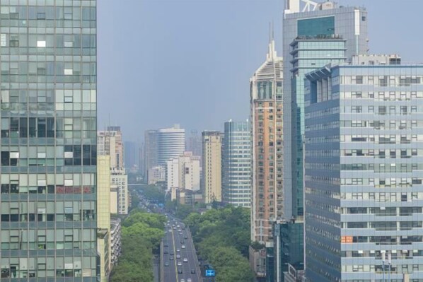Un paisaje urbano con modernos edificios altos, una calle despejada y una vista distante de una masa de agua.