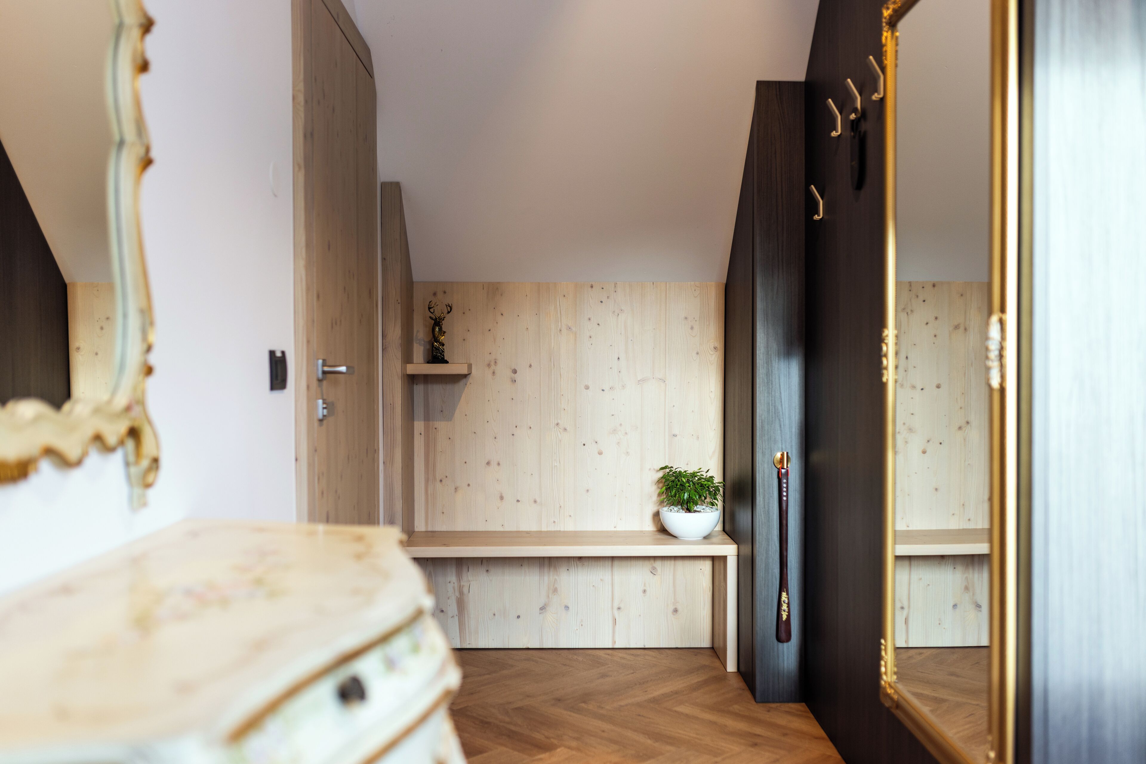 Ein modernes Badezimmer mit einem Holzbadezimmerkorpus, einem Spiegel und einem Ablagefächer mit einer Pflanze.