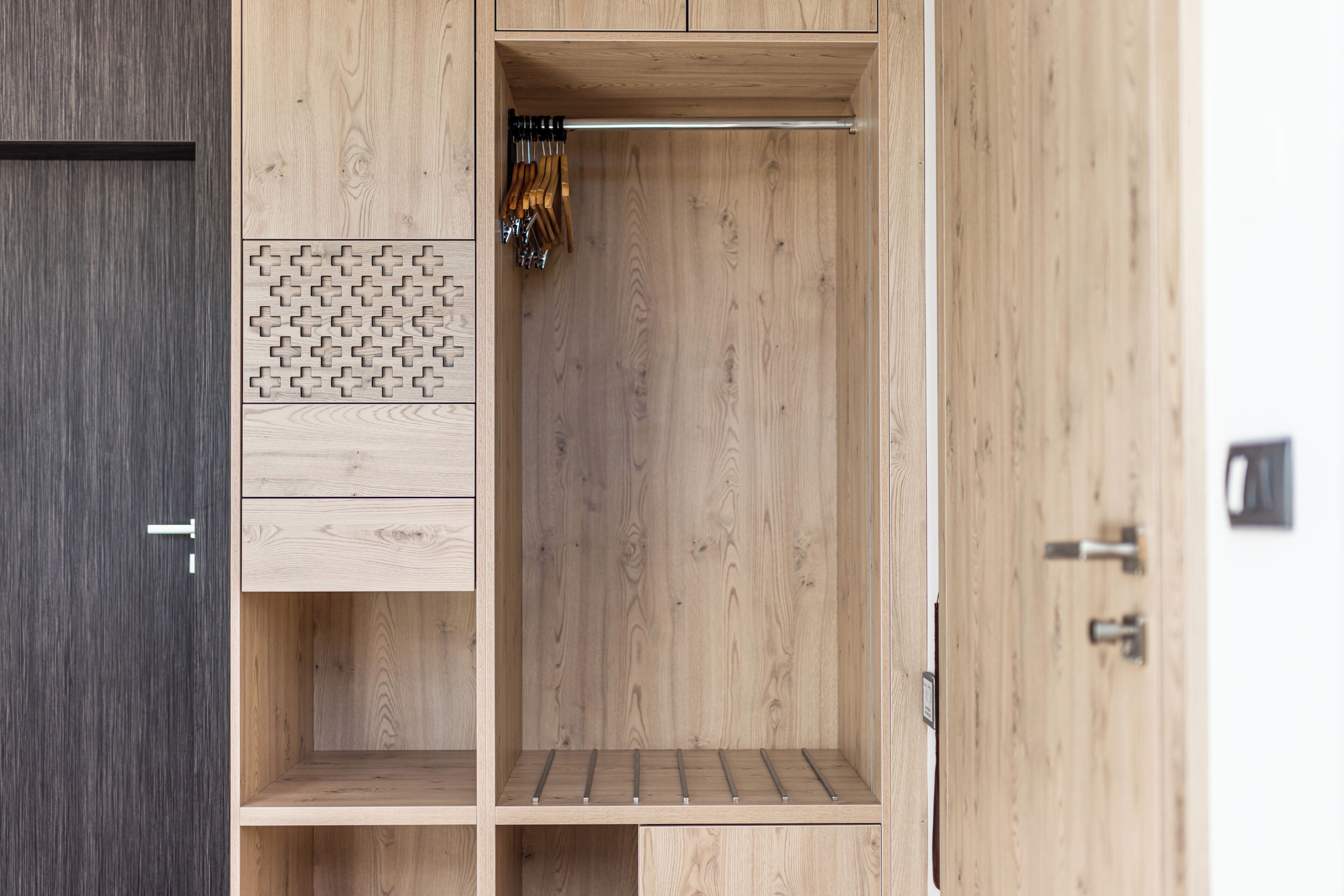 A wooden wardrobe with a hanging rod, a small shelf, and a drawer unit.