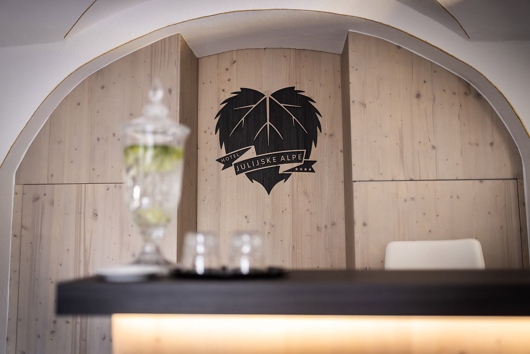Pared de madera con un logotipo y texto para Hotel Julijskke Alpe.