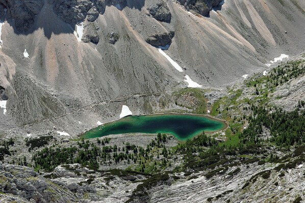 Un paisaje montañoso con un lago y vegetación escasa.
