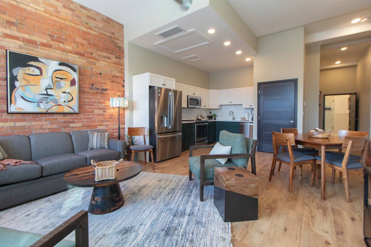 Un salon moderne comprenant un canapé, une table basse et un coin repas avec des chaises et une table.