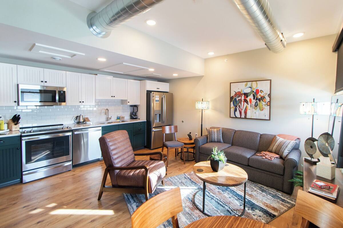 Un appartement moderne comprenant une cuisine, un salon et un coin repas.