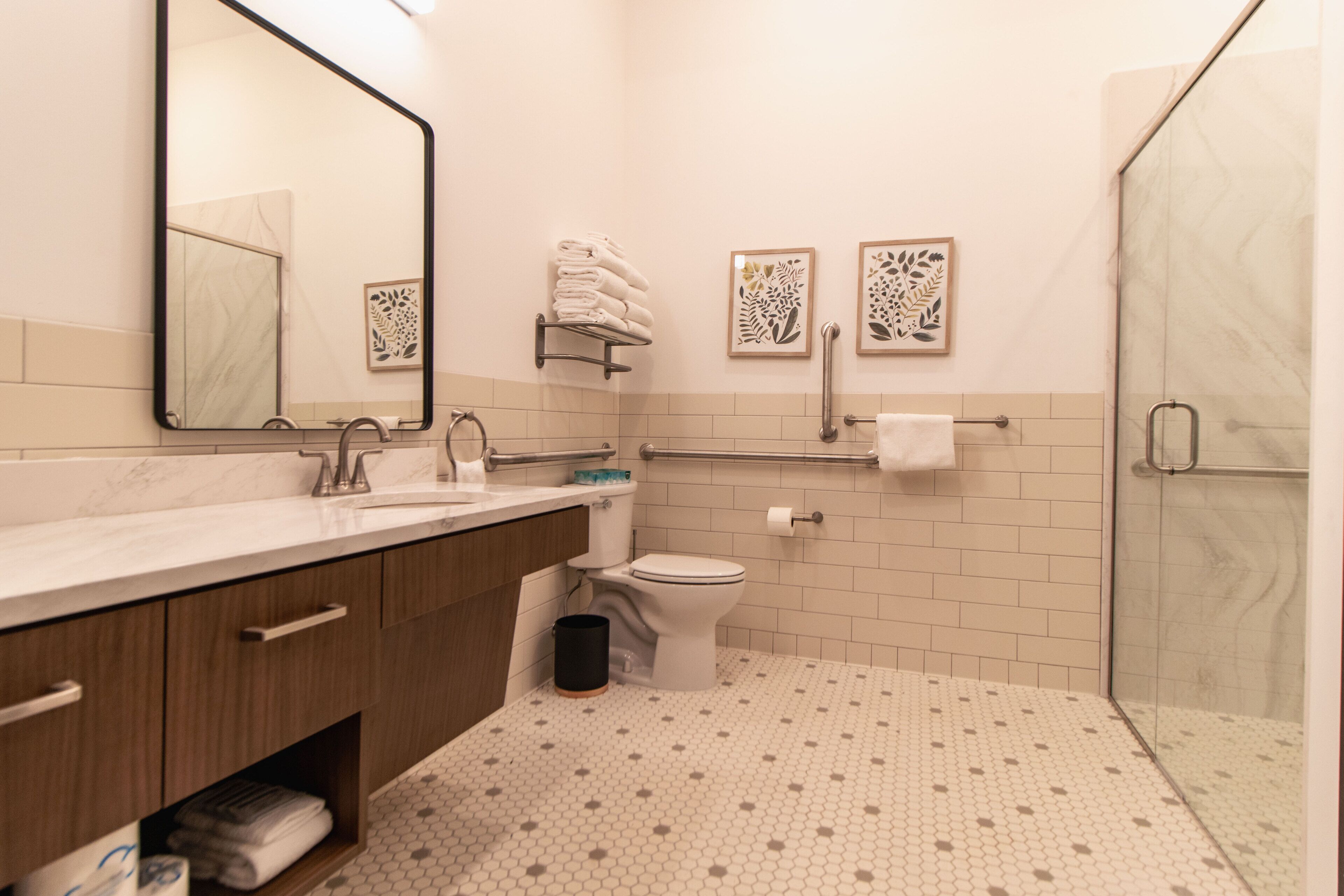 Une salle de bain moderne avec un lavabo en marbre, des toilettes et une douche à parois de verre.